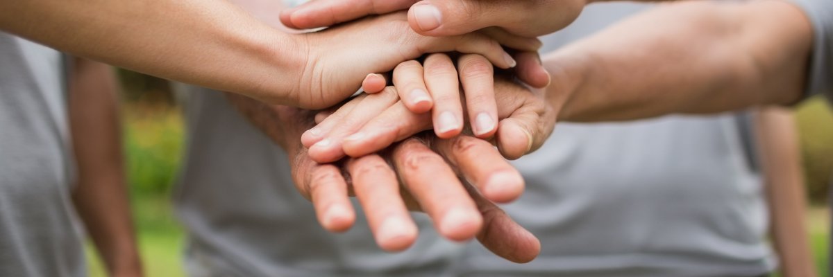 Happy volunteer family putting their hands together 